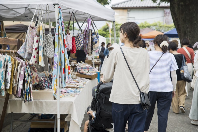 布小物のブースを見て歩くハンドメイドイベントの来場者