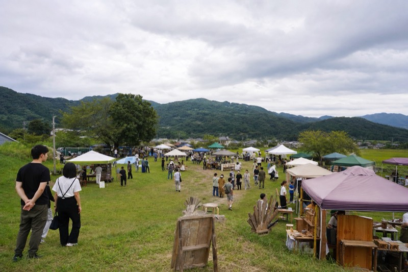 山を望む草地で開催されるクラフトマーケットの全景