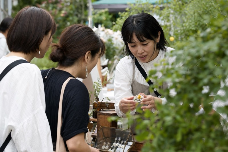 植物を使ったアクセサリーを見る来場者