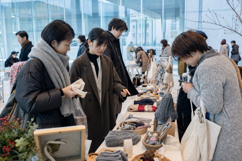 小さなハンドメイド作品を見比べる来場者