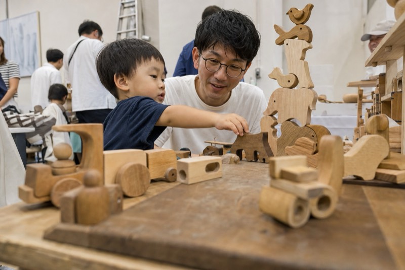 親子で手作りの木のおもちゃに触れる様子