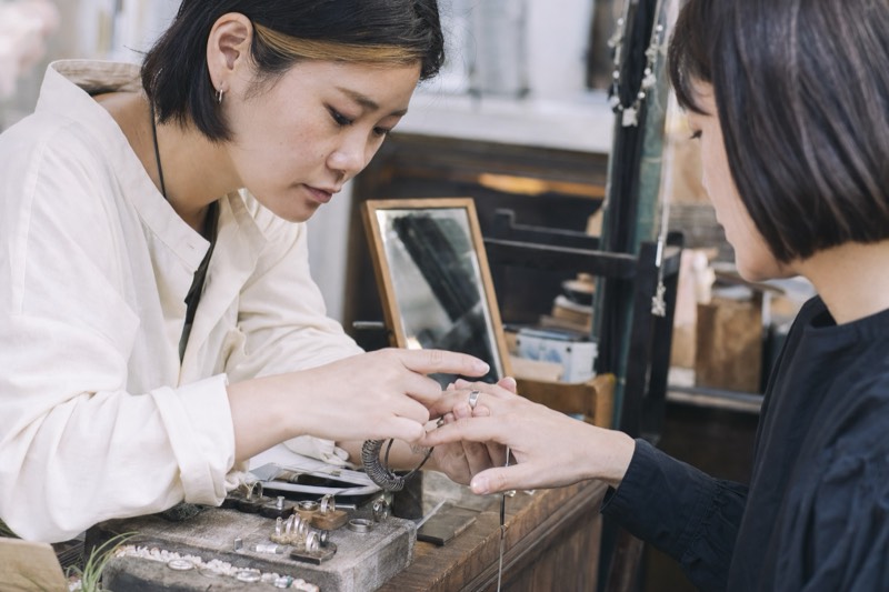 小さなアクセサリーを仕上げる作家の手元